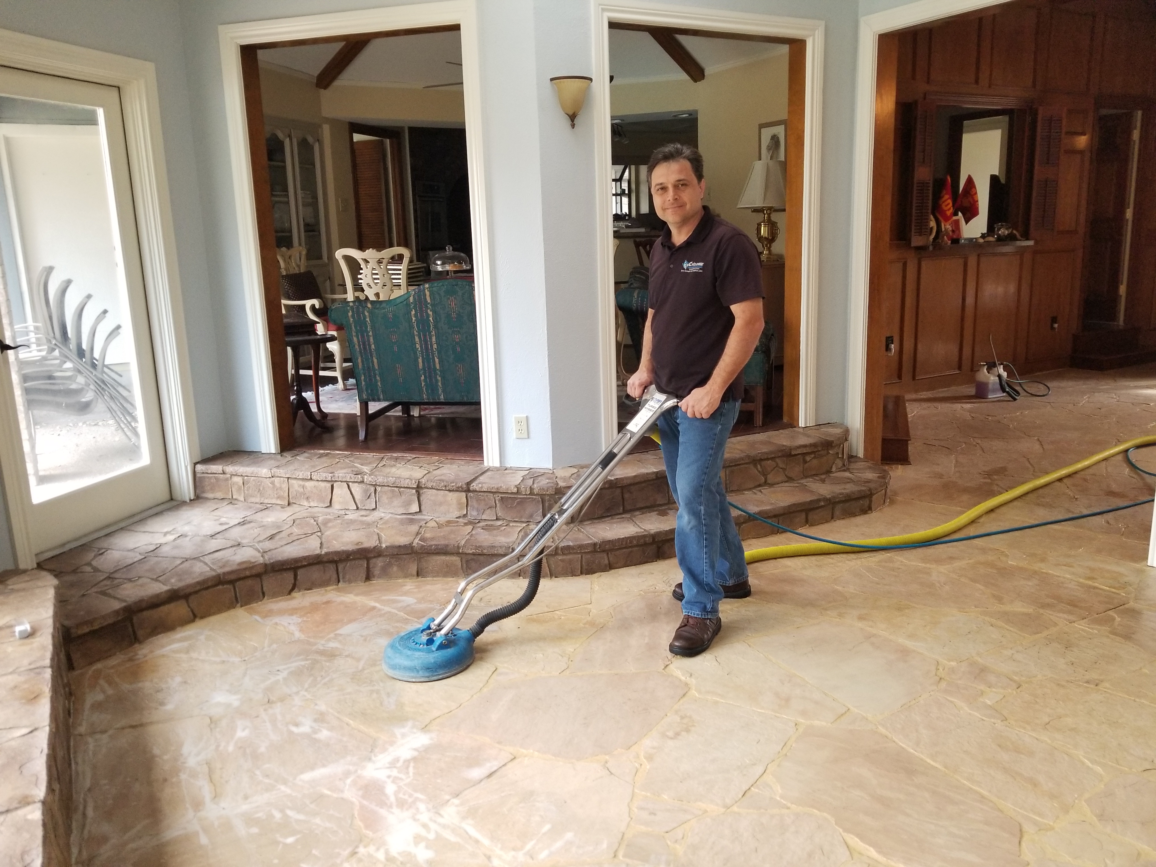 Frank Listorti cleans a stone floor at a home in Dallas