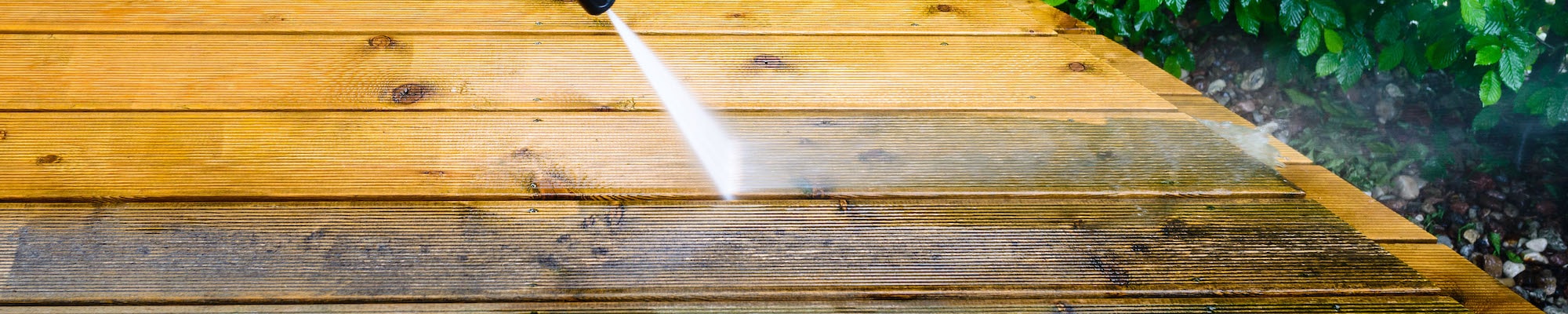 a wooden deck being power washed